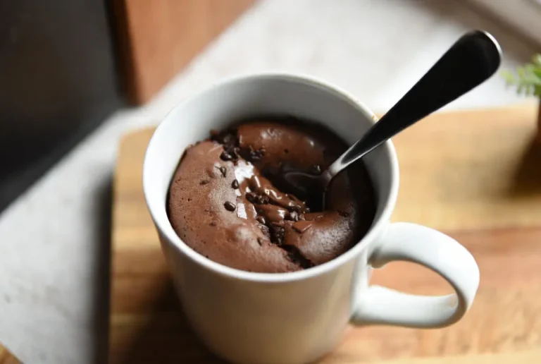Spoon digging into eggless chocolate mug cake no baking powder